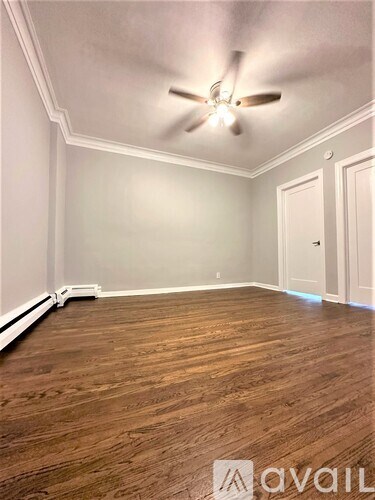 A room with wooden flooring and a ceiling fan.