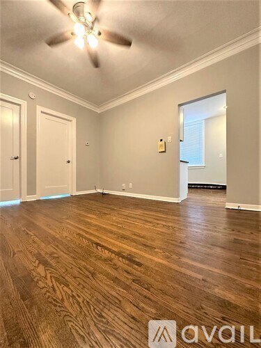 A room with wooden flooring and a ceiling fan.