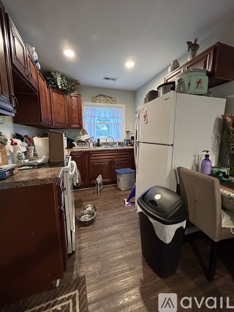A kitchen with a white fridge and wooden cabinets.