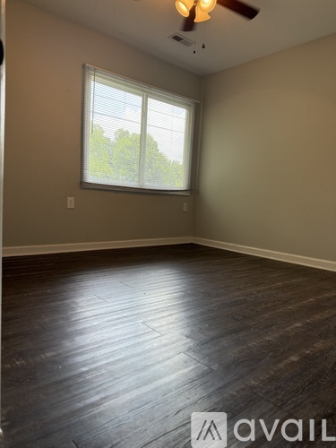 A room with a ceiling fan and a window with blinds.