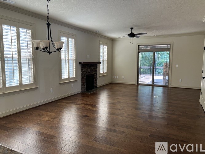 A spacious room with wood flooring and a fireplace.
