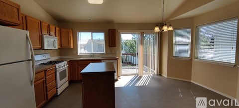 A kitchen with wooden cabinets and a white refrigerator.