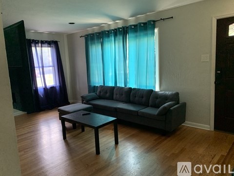 A living room with a grey couch and a wooden coffee table.