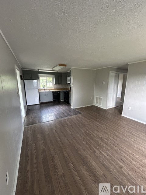 A room with wooden flooring and white walls.