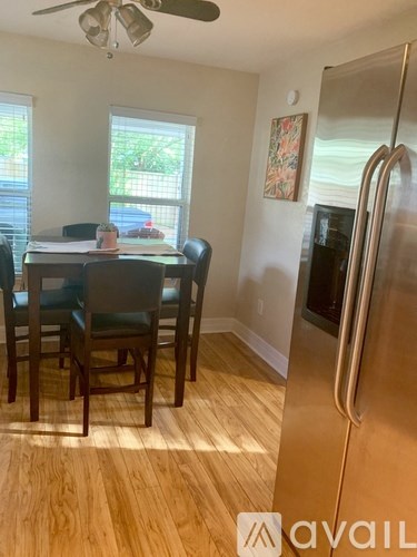 A kitchen with a table and chairs and a refrigerator.