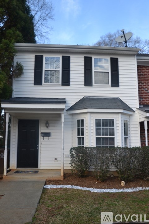 A white house with a black door and windows.