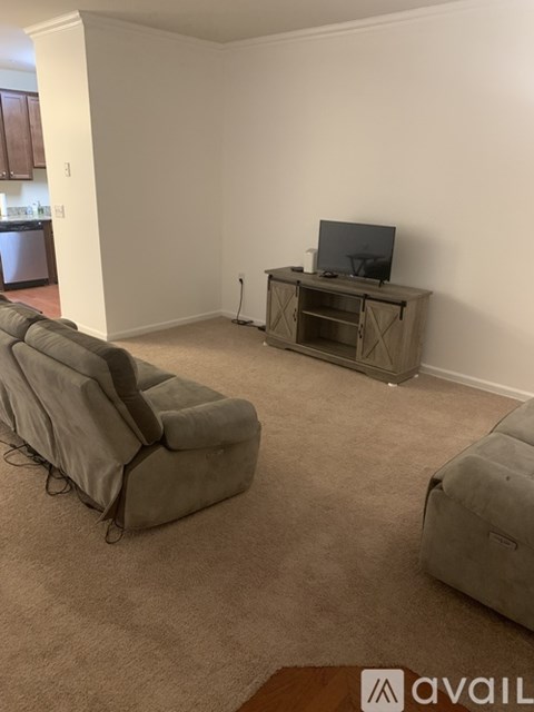 A living room with a grey sofa and a television on a cabinet.