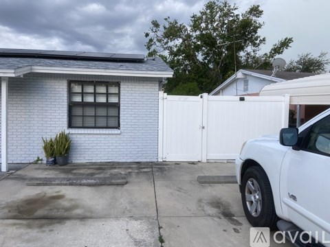 A white car is parked in front of a house.