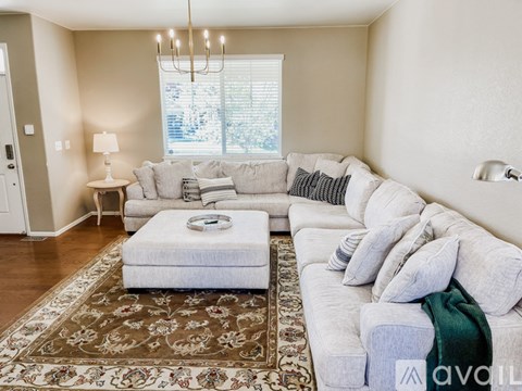 A living room with a white couch and a rug.