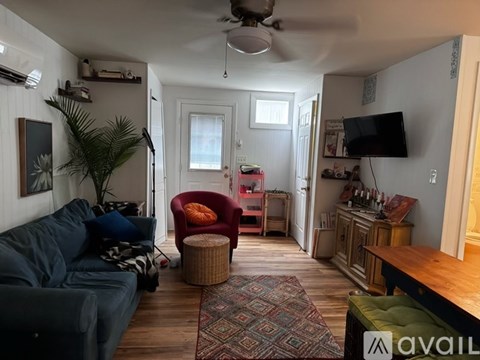 A living room with a blue couch and a red chair.
