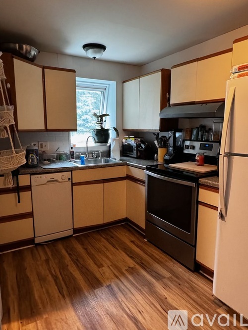 A kitchen with wooden floors and white appliances.
