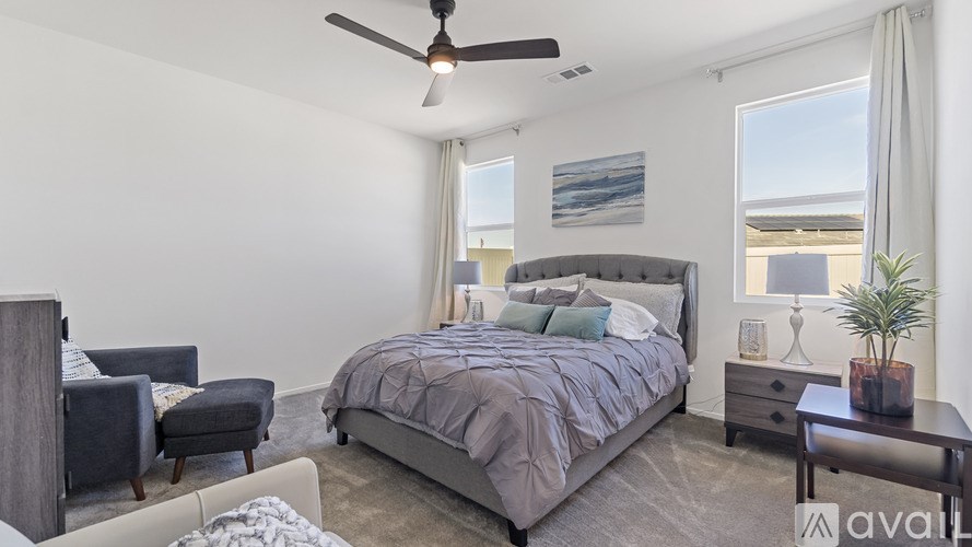 A bedroom with a large bed and a ceiling fan.