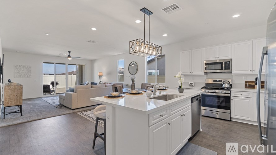 A modern kitchen with white cabinets and stainless steel appliances.