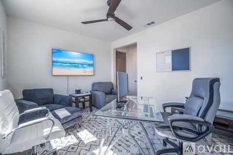 A living room with a television and a glass table.