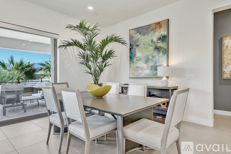 A modern dining room with a glass table and chairs.