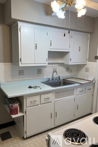 A kitchen with white cabinets and a sink.