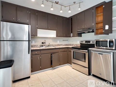 A kitchen with brown cabinets and stainless steel appliances.