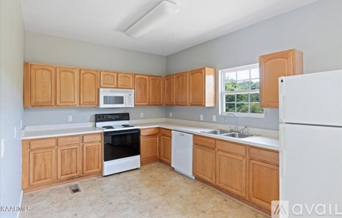 A kitchen with wooden cabinets and white appliances.