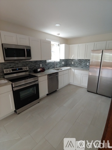 A modern kitchen with white cabinets and stainless steel appliances.
