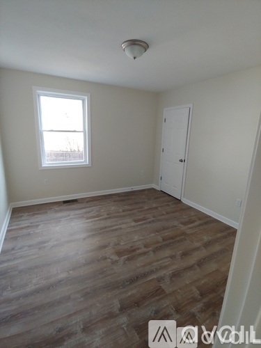 A room with wooden flooring and a window.