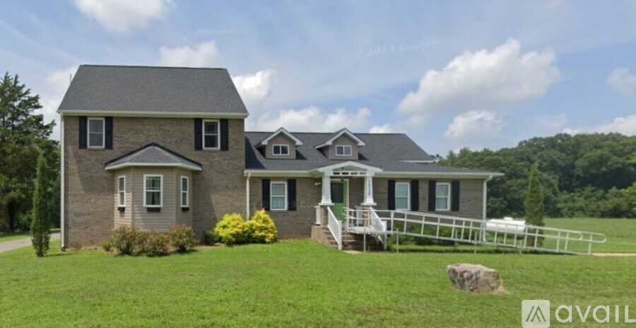 A house with a grey roof and a white fence in front.