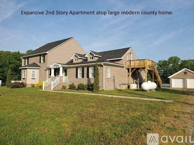 A large modern house with a two-story apartment on top.