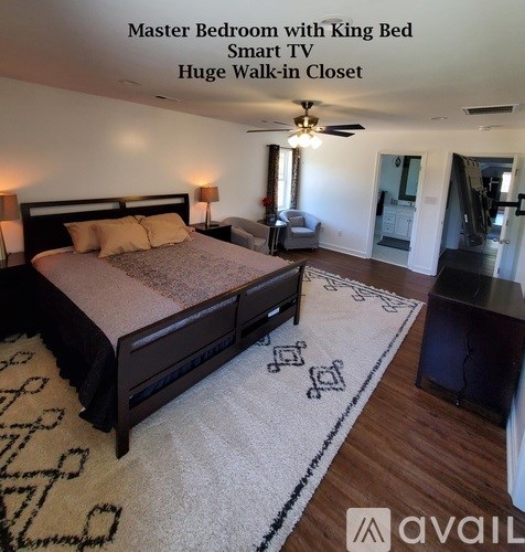A bedroom with a king size bed and a walk-in closet.