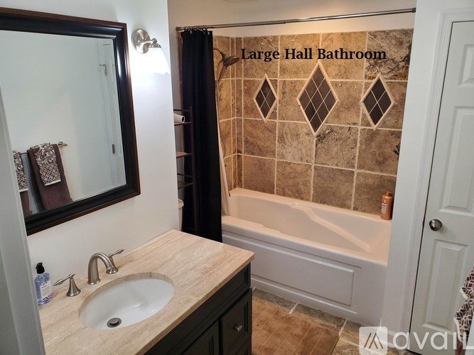 A bathroom with a sink, mirror, and bathtub.