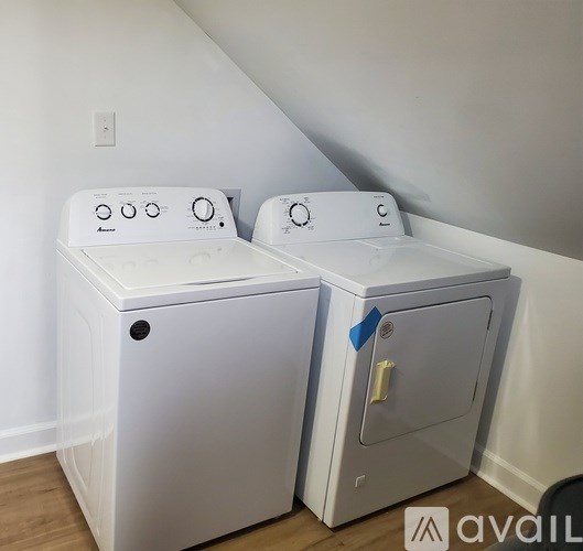 Two white washing machines are sitting next to each other.