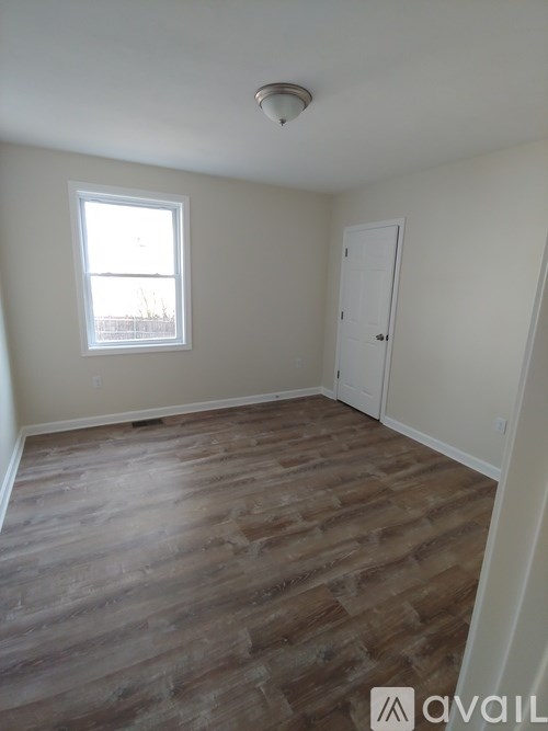 A room with wooden flooring and a window.