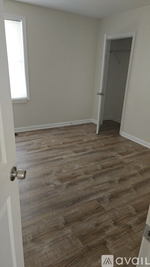 A room with a wooden floor and a white door.