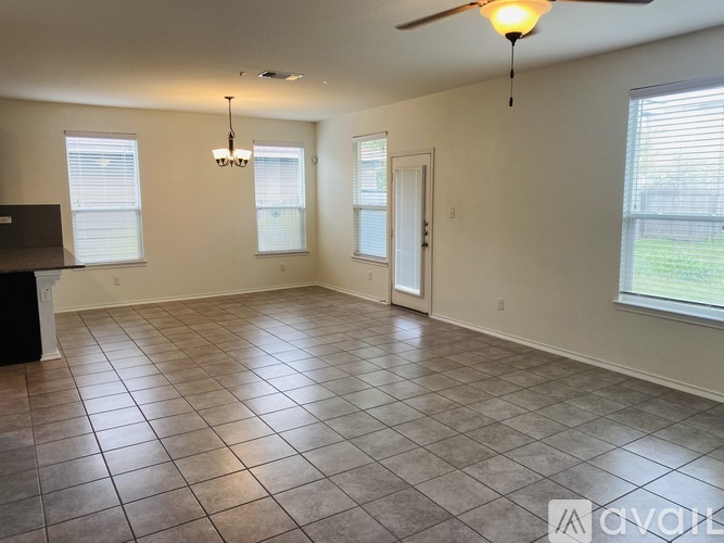 A spacious room with a ceiling fan and tiled flooring.