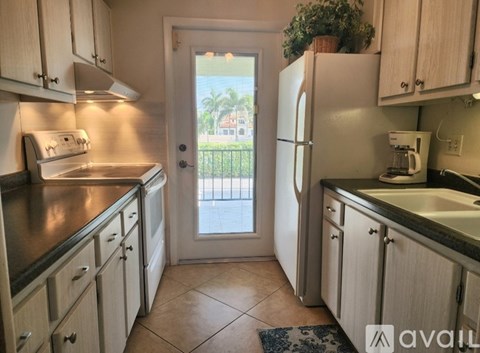 A kitchen with wooden cabinets and a tiled floor.