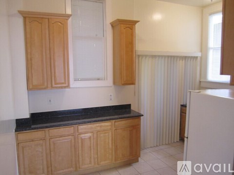 A kitchen with wooden cabinets and a black countertop.