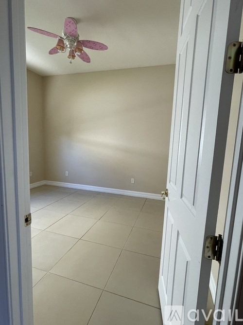 A room with a ceiling fan and a closed door.