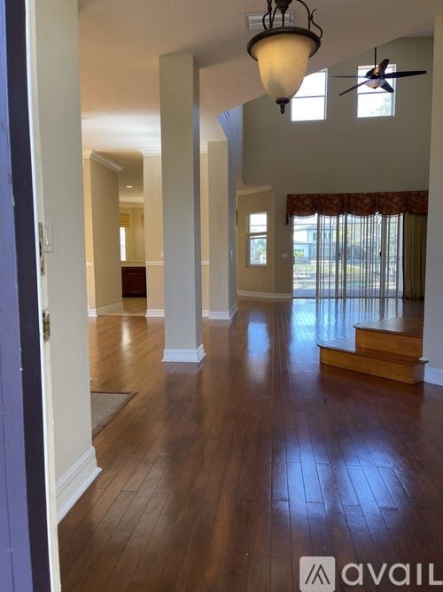 A large open room with wooden floors and a hanging light fixture.