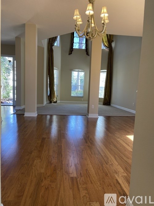 A room with wooden floors and a chandelier.