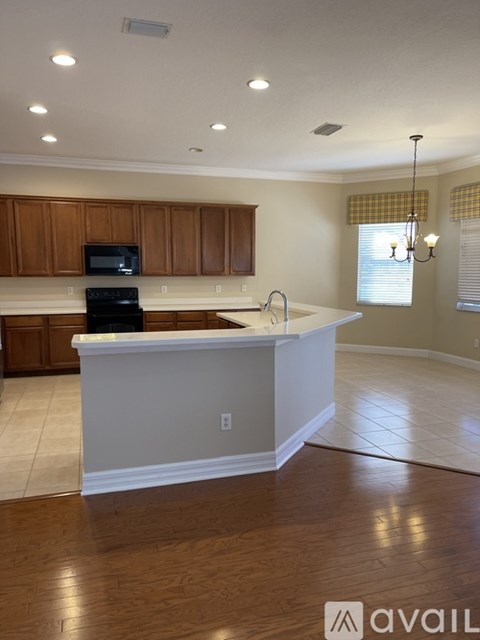 A kitchen with wooden cabinets and a black stove top oven.