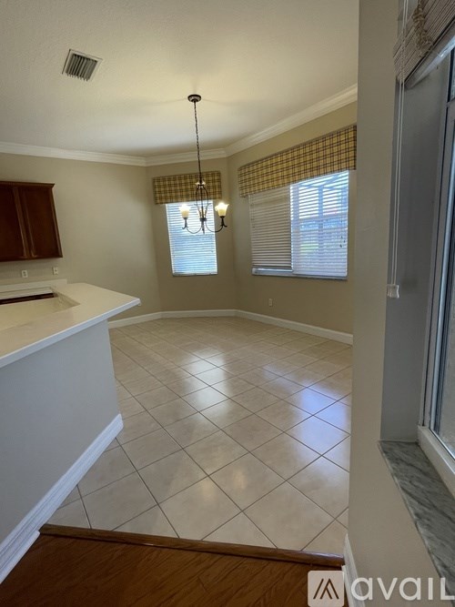 A kitchen with white tiled floors and a wooden floor.