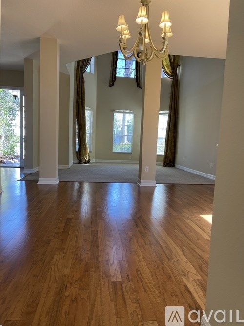 A room with wooden floors and a chandelier.
