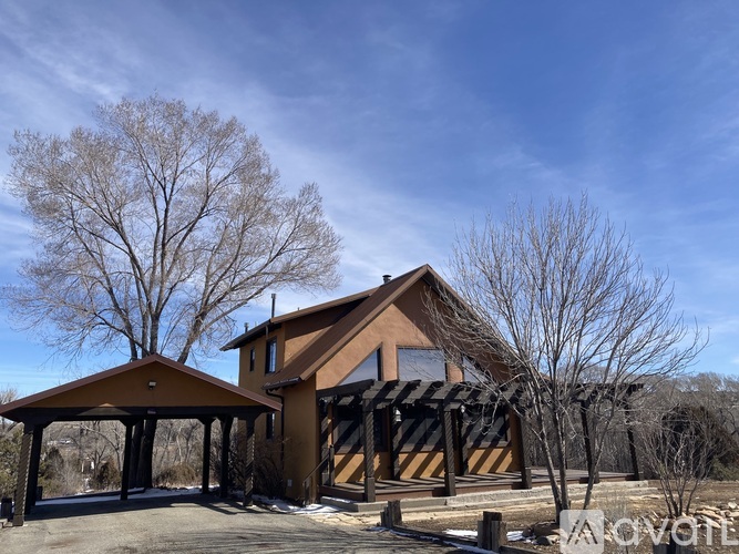 A house with a brown roof and a covered patio area.