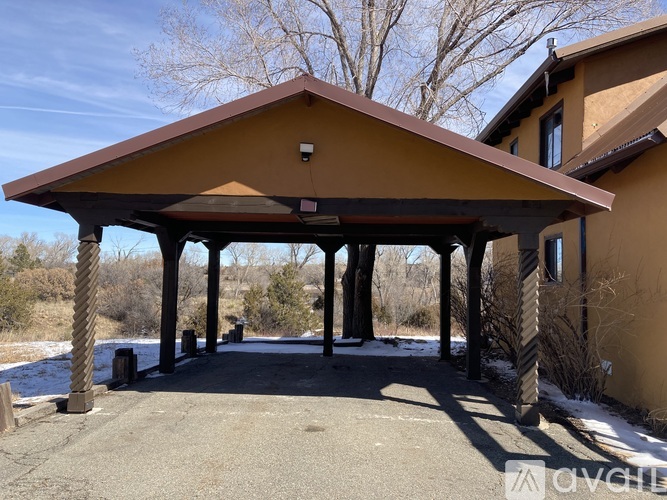 A covered patio area with a roof and pillars.