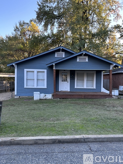 A blue house with white windows and a white door.