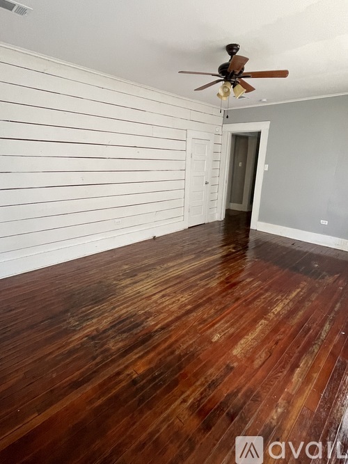 A room with wooden floors and a ceiling fan.