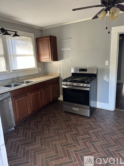 A kitchen with a black stove top oven and a fan.