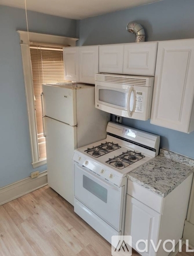 A kitchen with white appliances and cabinets.