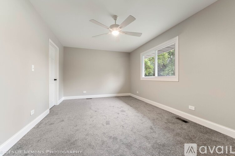 A spacious room with a ceiling fan and a window.