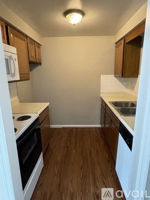 A small kitchen with white appliances and wooden cabinets.