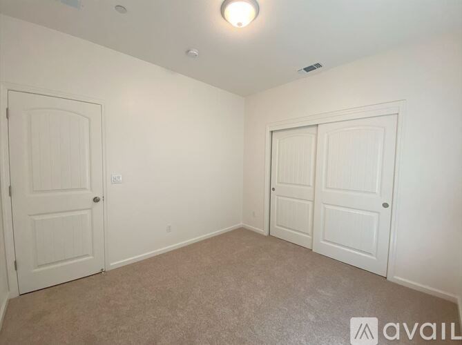 A room with two doors and a carpeted floor.