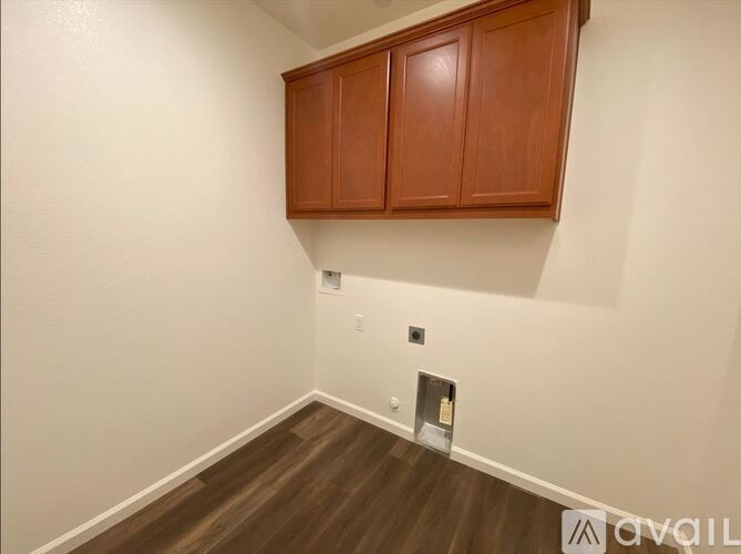 A room with wooden floors and a brown cabinet.